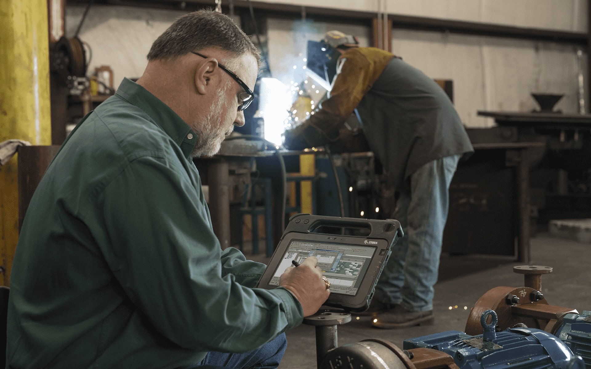 Client using MobileManage software on a tablet in a machine shop